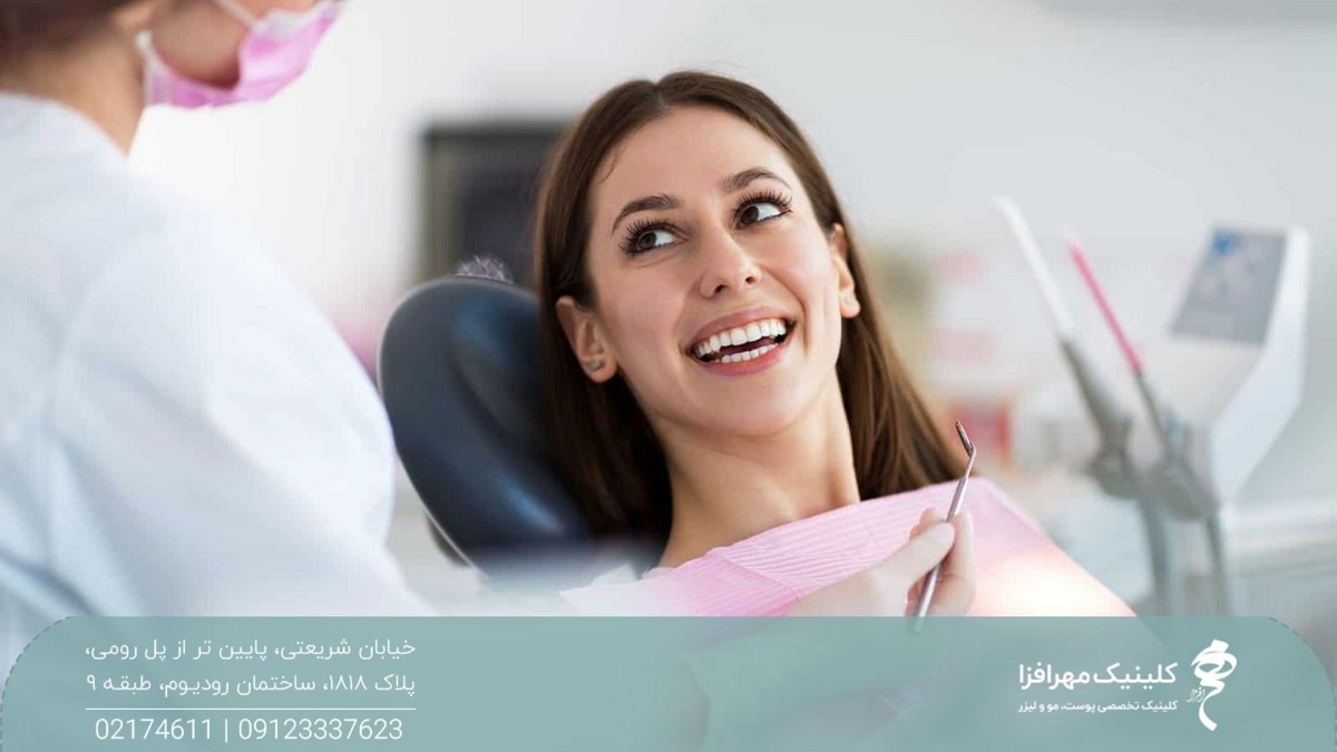 دختری که روی صندلی جراحی است و به پزشک نگاه می کند و لبخند می زند