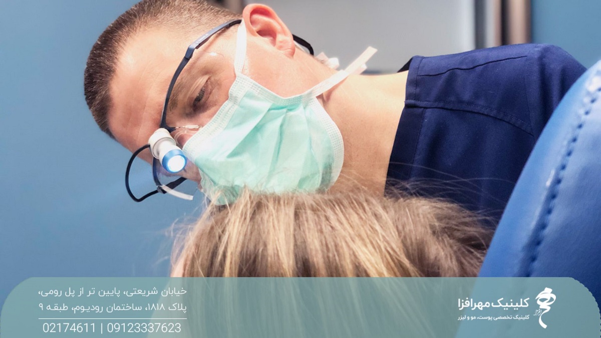 جراح مردی که بالای سر دختر ایستاده و روی صورت او جراحی می کند
