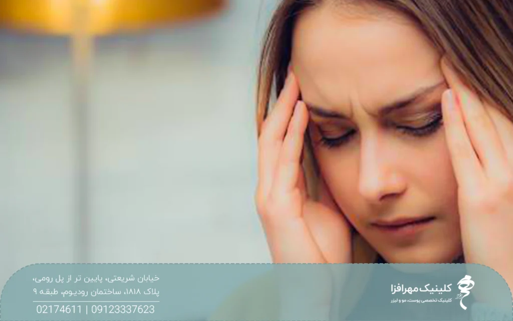 خانمی که دچار سردرد شده و هر دو دستش روی شقیقه هایش است