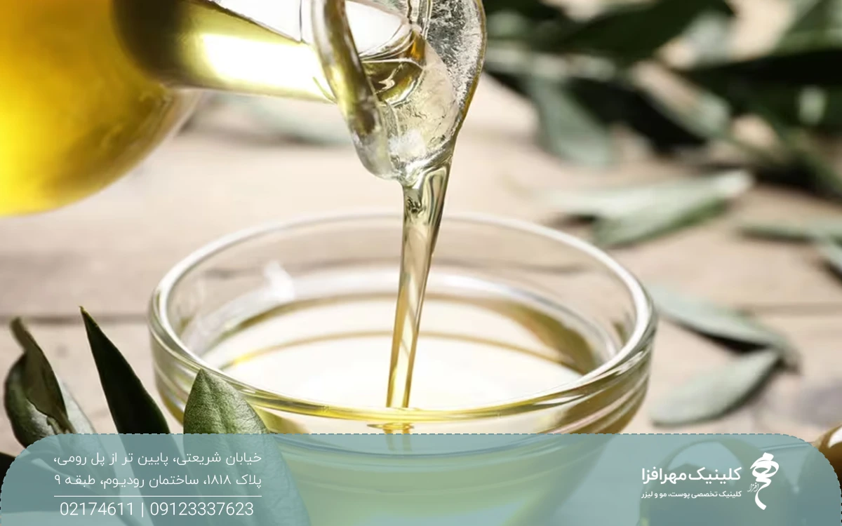 یک شیشه روغن زیتون که روغن داخل آن در یک کاسه ریخته می شود