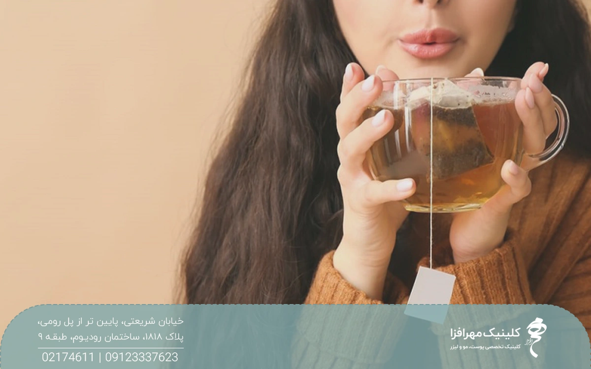دستان خانومی که یک فنجان چایی در آن است و در حال فوت کردن آن است