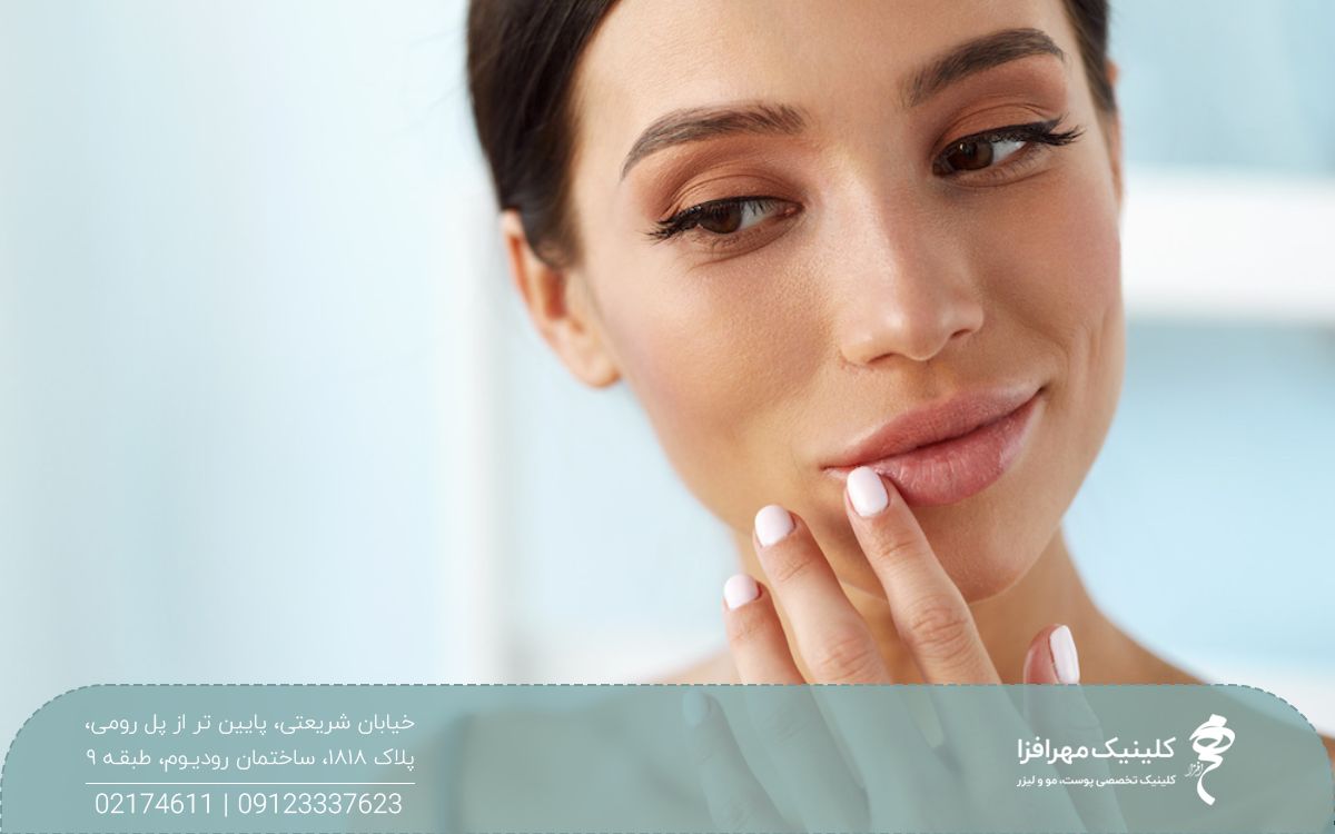 دختری که لبخند زده است و انگشتش را روی لب پایینش گرفته است