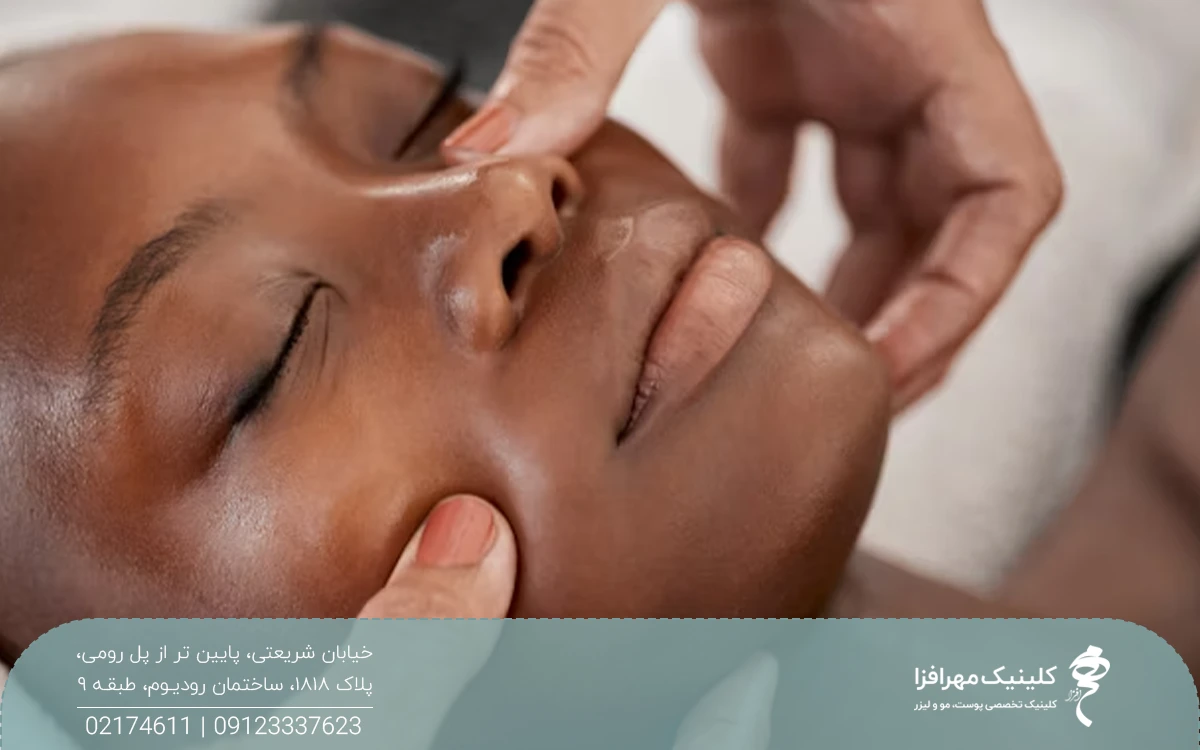دختری که چشمش بسته است و فرد دیگری صورت او را ماساژ می دهد